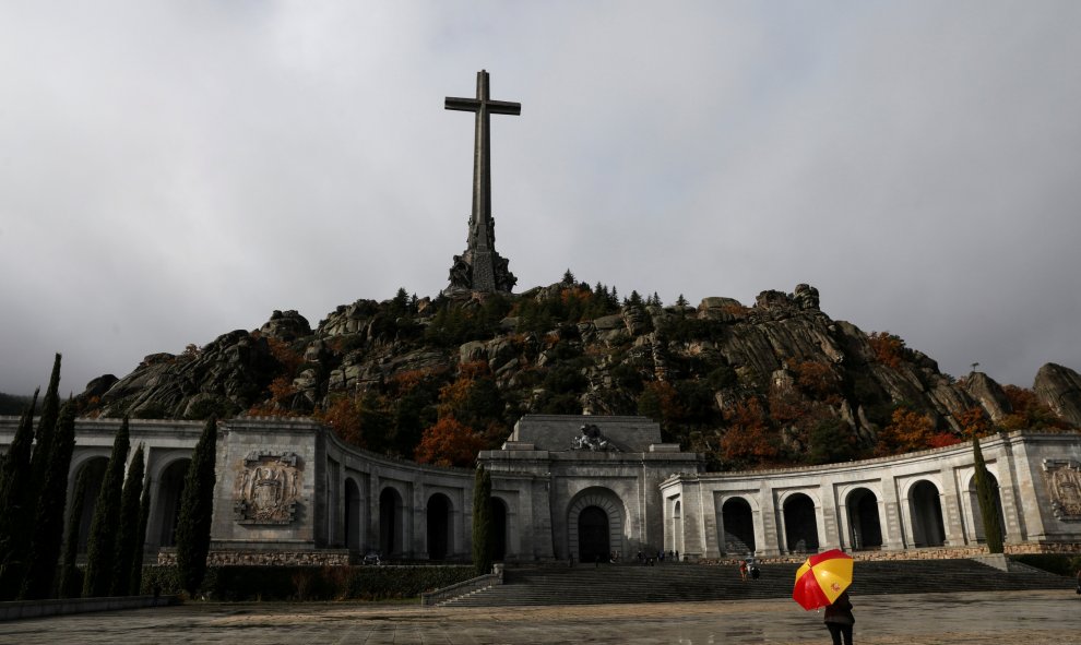 Un hombre con un paraguas con los colores de la bandera española en la explanada de la Basílica del Valle de los Caidos. REUTERS/Susana Vera