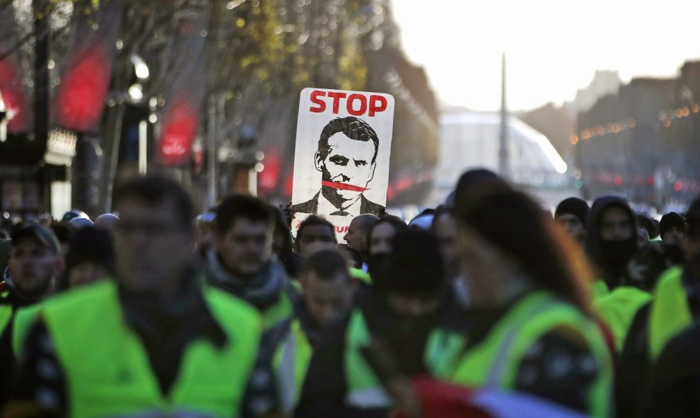 Los chalecos amarillos portan una pancarta contra Macron en la manifestación de este sábado en París..EFE/Ian Langsdon