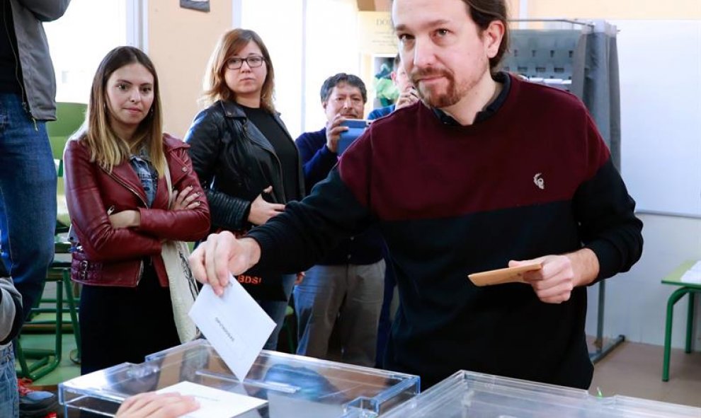 El líder de Podemos, Pablo Iglesias,saluda a los integrantes de la mesa electoral en el colegio Público de La Navata donde votó hoy