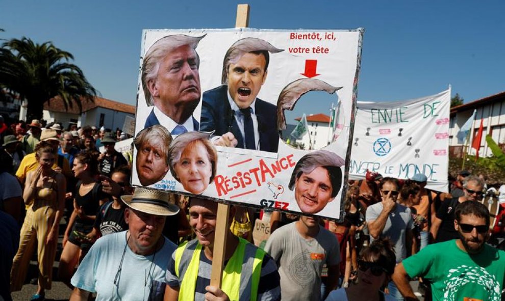 Los manifestantes sostienen una pancarta durante una manifestación de la Contracumbre del G7