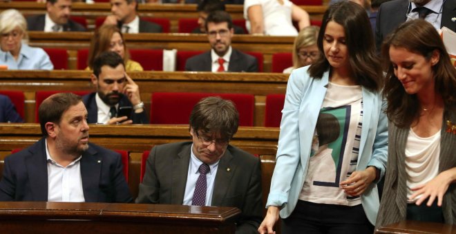 Las diputadas Inés Arrimadas, de Ciudadanos, y Andrea Levy, del PP, pasan junto a los escaños del president de la Generalitat, Carles Puigdemont, y del vicpresidente, Oriol Junqueras, en Parlament de Catalunya. EFE/Toni Albir