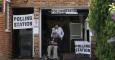 Dos personales salen de votar en una mesa electoral instalada en el garaje de una casa de Croydon. - AFP