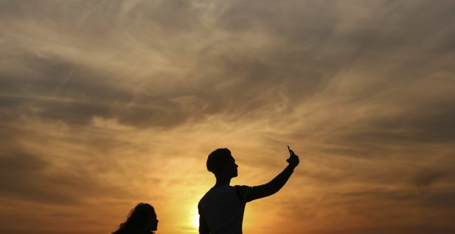 Varias personas se hacen un selfie en el paseo marítimo de Bandra Fort Band Stand junto al mar arábigo en Bombay, India. EFE/Divyakant Solanki