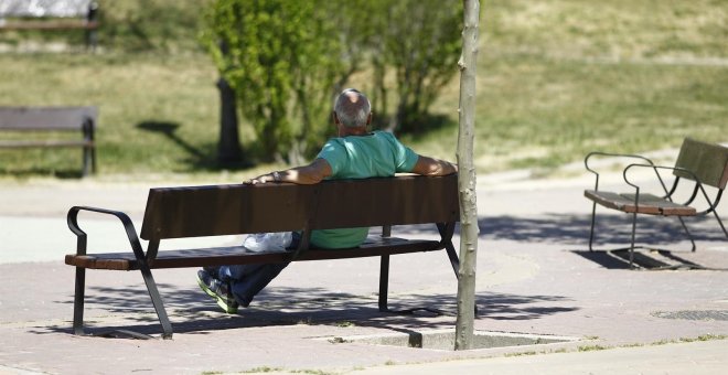 Un hombre sentado en un banco en un parque. E.P.