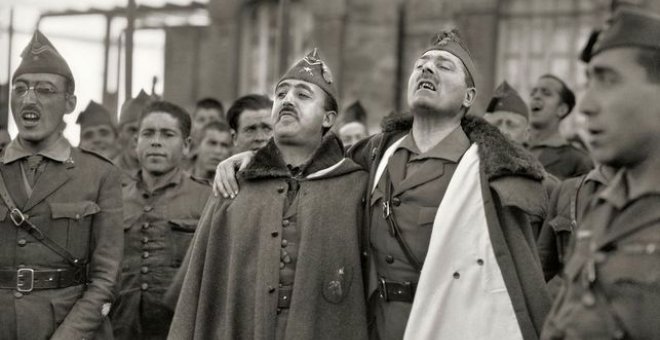 Francisco Franco y Millán Astray abrazados mientras entonan cánticos legionarios