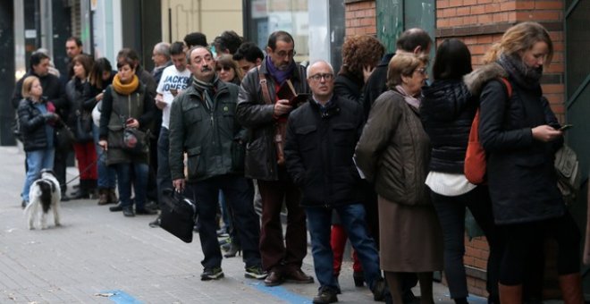 Varias personas hacen cola para votar en un colegio de Barcelona minutos antes de que abra sus puertas. /REUTERS