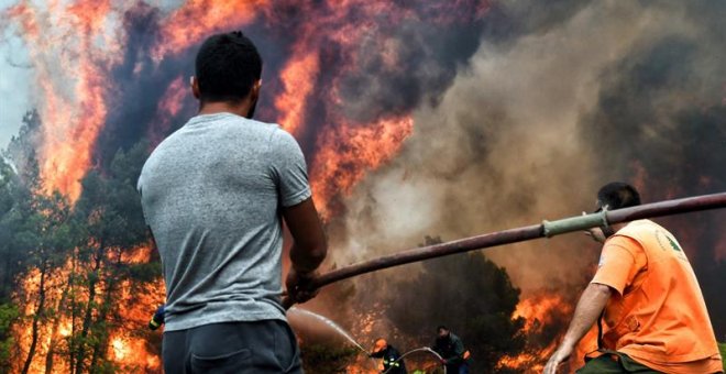 Varios bomberos y voluntarios luchan contra las llamas en un incendio en Verori/EFE