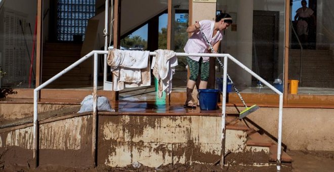 11/10/2018.- Una mujer en las tareas de limpieza en la desembocadura del torrente desbordado en S'Illot, Manacor, tras el temporal. EFE /LLITERES