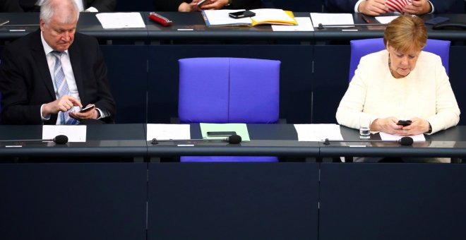 Fotografía de archivo de la canciller alemana Angela Merkel y el ministro del Interior, Horst Seehofer, usando sus móviles en el Bundestag. /REUTERS