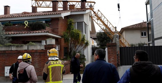 10/02/2019.- Bomberos en las inmediaciones del lugar en el que un operario ha fallecido y otro ha resultado herido menos grave al caer este domingo una grúa de construcción sobre un edificio en Sant Just Desvern (Barcelona). EFE/Toni Albir