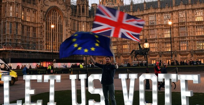 Un manifestante anti-Brexit ondea banderas frente a las Casas del Parlamento en Londres, | Reuters