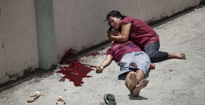 Kevin Ignacio Vázquez de 17 años yace muerto en brazos de su madre tras ser asesinado a tiros frente a la escuela del Barrio Cabañas de San Pedro Sula. Esta ciudad es el punto más violento de Honduras y en 2010 se convirtió en la ciudad más violenta del