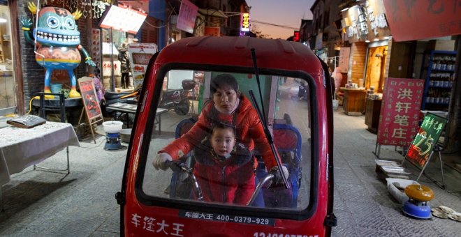 Una mujer y un niño en un triciclo eléctrico en la parte antigua de la ciudad de Luoyang, en la provincia china de Henan. REUTERS/Thomas Peter