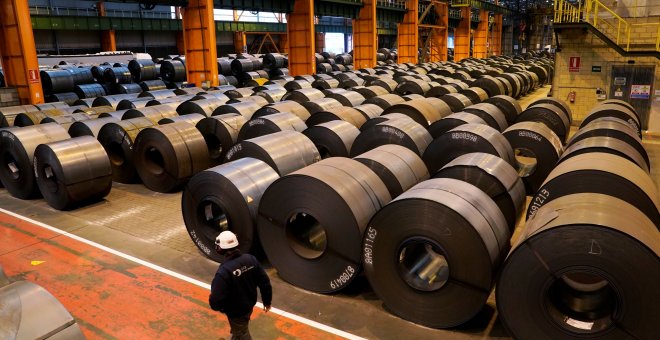 Un trabajador pasa junto a las bobinas de acero en la planta de ArcelorMittal en Sestao (Vizcaya). REUTERS