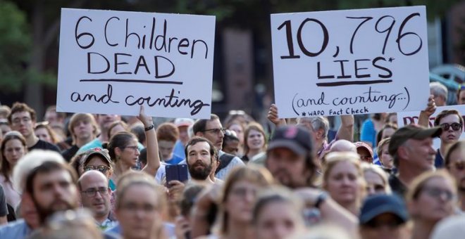 Manifestantes sostienen carteles en los que se leen "6 niños muertos y contando" (i) y "10.796 mentiras y contando" (d) -en referencia al presidente Trump- durante una manifestación este viernes, fuera de la Casa Blanca, en Washington (EE.UU.). La protest