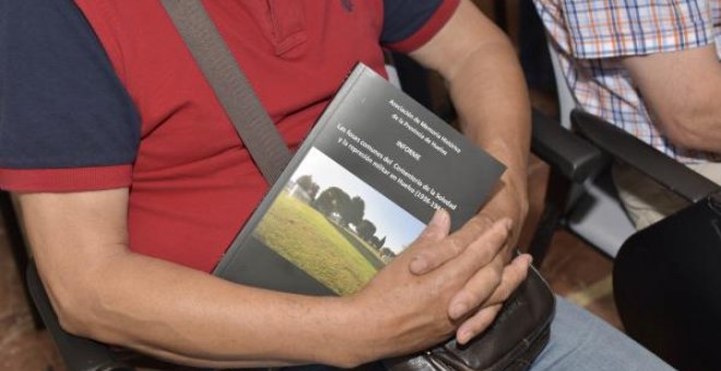 Hombre sujetando el informe "Las fosas comunes del cementerio de La Soledad y la represión militar en Huelva (1936-1944)". / EUROPA PRESS