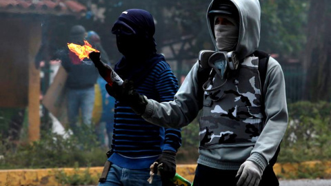 Manifestantes opositores se enfrentan a agentes de la Guardia Nacional Bolivariana mientras bloquean una calle en rechazo a las elecciones de la Asamblea Nacional Constituyente, en Barquisimeto. EFE/Pascuale Giorgio