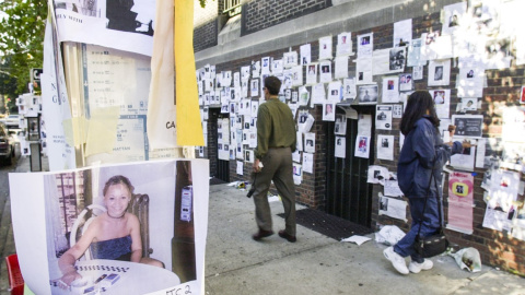 Un hombre y una mujer pasan junto a una pared llena de carteles de los desaparecidos tras el ataque al World Trade Center en Nueva York el 11-S. EFE / EPA / TANNEN MAURY