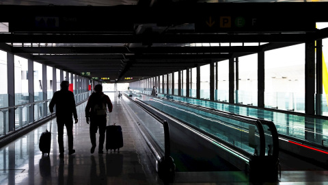 Dos pasajeros cruzan una de las terminales del Aeropuerto Adolfo Suárez Madrid-Barajas.