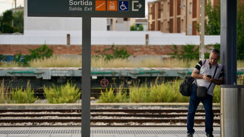 Un usuari, esperant un tren a l'andana de l'estació de Sant Vicenç de Calders