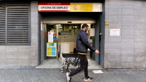 Un hombre pasa con su perro por la oficina de empleo de Acacias, a 4 de octubre de 2022, en Madrid (España).