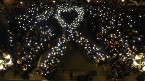 Els manifestants dibuixen amb els seus mòbils el signe de solidaritat amb el presos, un llaç gegant a la plaça de Sant Jaume