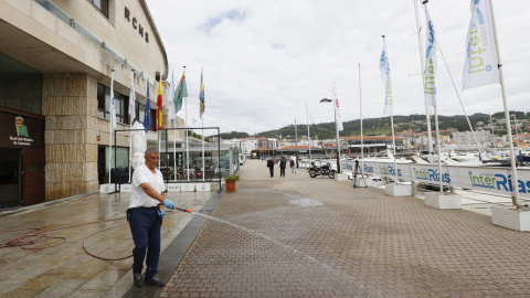 Un empleado del Real Club Náutico de Sanxenxo limpia al acceso a las instalaciones este miércoles. El rey emérito Juan Carlos I se hospedará en casa de su amigo Pedro Campos, presidente del Real Club Náutico de Sanxenxo, durante su estancia en el mun