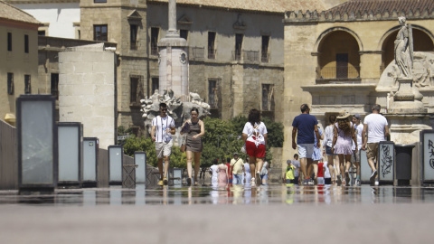 Turistas pasean el pasado 6 de agosto por el puente romano de Córdoba con botellas de agua y abanicos por las altas temperaturas registradas en Córdoba con aviso amarillo por calor.