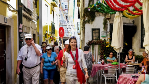 Guía turística dirige a unos turistas por las calles de Lisboa AFP / PATRICIA DE MELO MOREIRA