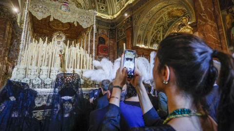 Una joven fotografía el paso de Semana Santa de la virgen de la Macarena en la Basílica de La Macarena, en Sevilla, horas antes de que salga en procesión en la tradicional 'Madrugá'. EFE/Jose Manuel Vidal