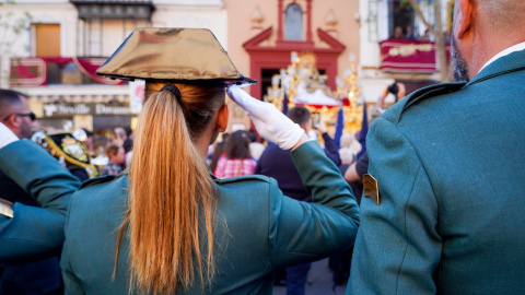 Una agente de la Guardia Civil saluda la salida del paso de La Piedad de la Hermandad del Baratillo, en Sevilla. E.P./Eduardo Briones