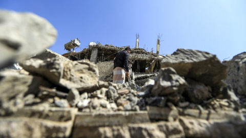 Un hombre busca entre los escombros de un edificio derruido tras un ataque aéreo de Arabia Saudí en Saná, la capital de Yemen. - AFP