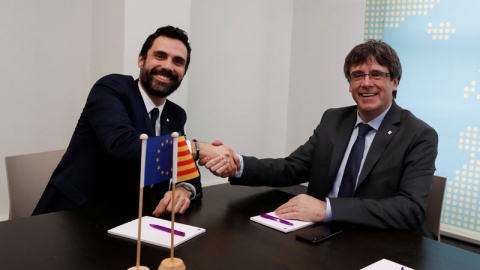 Roger Torrent y Carles Puigdemont se saludan al inicio de su reunión en Bruselas. | YVES HERMAN (REUTERS)