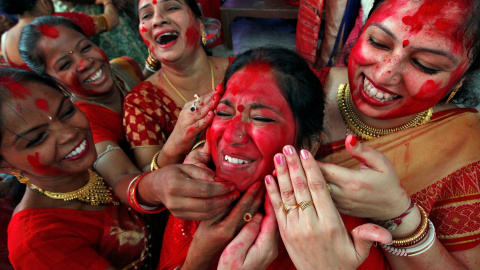 Varias mujeres indias echan sindhur' (polvo bermellón) a una de ellas durante un acto religioso en la ciudad de Chandigarh. - REUTERS