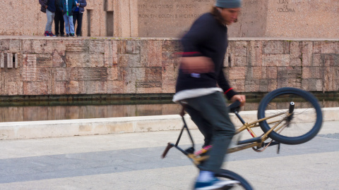 Viki Gómez realiza uno de sus trucos con la bici mientras varios niños le observan a lo lejos. CHRISTIAN GONZÁLEZ