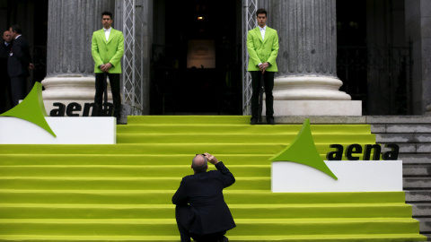 Un hombre toma una foto en la entrada del edificio de la Bolsa de Madrid el día del estreno en el mercado de AENA, en febrero de 2015.  REUTERS/Susana Vera