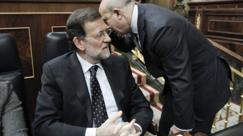 Mariano Rajoy escucha una confidencia del entonces ministro de Educación, José Ignacio Wert, en un debate de Presupuestos en el Congreso de los Diputados. EFE