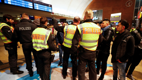 Agentes de Policía interrogan a jóvenes en la principal estación de trenes de Colonia. /REUTERS