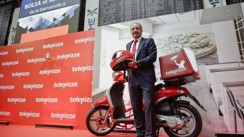 El presidente de Telepizza, Pablo Juantegui, compañía que se ha estrenado en la Bolsa de Madrid, posa en el parqué madrileño junto a una de las típicas motos de reparto. EFE/Emilio Naranjo