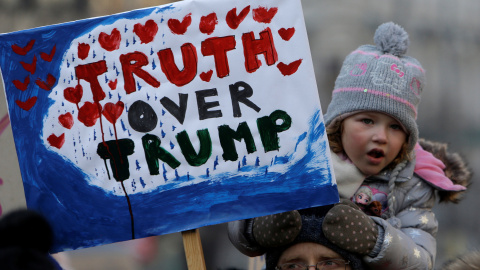 Una niña sostiene una pancarta contra Trump donde se lee "Truth over Trump"  en Praga / REUTERS