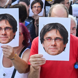 Seguidores del expresidente catalán Carles Puigdemont aguardan, con una caretas con su rostro, su llegada a Barcelona tras siete años de exilio. REUTERS/Lorena Sopena