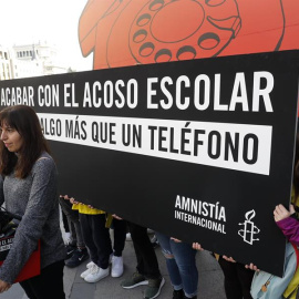 GRAF8275. MADRID, 28/02/2020.- Jóvenes activistas de Amnistía Internacional despliegan un teléfono de disco gigante en la puerta principal del Ministerio de Educación este viernes en Madrid para denunciar que el actual sistema de denuncias de acoso es