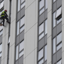 Un desciende por una de las fachadas de la Bray Tower para revisar su revestimiento. REUTERS / Toby Melville