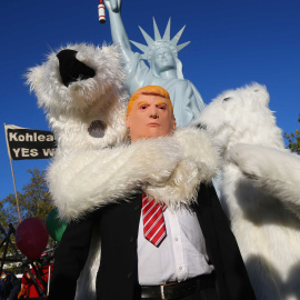 Un manifestante vestido con una máscara del presidente de EEUU Donald Trump junto a otros manifestantes disfrazados de osos polares, durante una manifestación de organizaciones ecologistas en Bonn, ante la cumbre del  clima COP23. REUTERS / Wolfgang Rat