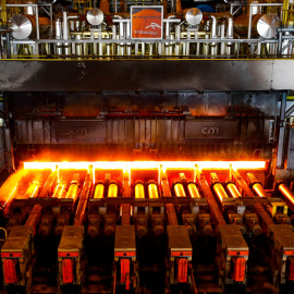 Una placa de acero al rojo vivo pasa a través de una prensa en la planta de ArcelorMittal en Gante, Bélgica. REUTERS / Yves Herman