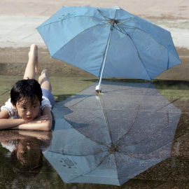 03/06/2024-Un niño mojado con un paraguas al lado, señal de que la Niña trae precipitaciones