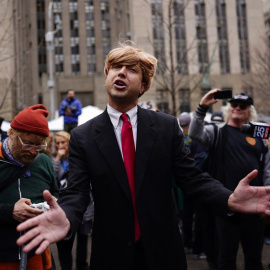 Un imitador de Donald Trump rodeado de periodistas a las afueras del juzgado de Nueva York donde se leerán los cargos al expresidente, a 4 de abril de 2023.