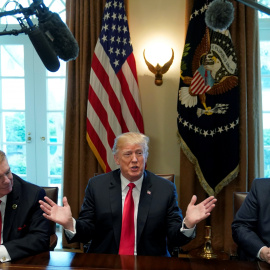 El presidente ejecutivo de Nucor John Ferriola, y el consejero delegado de US Steel, Dave Burritt, flanquean al presidente estadounidense Donald Trump durante el anuncio de aranceles a las importaciones de acero y de aluminio. REUTERS / Kev