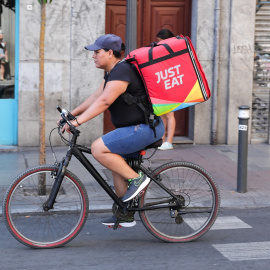 Un repartidor de la empresa Just Eat transitando en bicicleta por una calle del centro de Madrid.