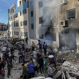 Un grupo de bomberos trabaja tras el ataque aéreo israelí en la escuela Salahaddin (Gaza) del 14 de diciembre de 2024, donde se refugiaron los palestinos desplazados